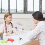 little-blonde-girl-showing-drawn-house-paper-her-female-psychologist_23-2148026288.jpg
