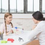 little-blonde-girl-showing-drawn-house-paper-her-female-psychologist_23-2148026288.jpg
