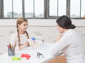 little-blonde-girl-showing-drawn-house-paper-her-female-psychologist_23-2148026288.jpg